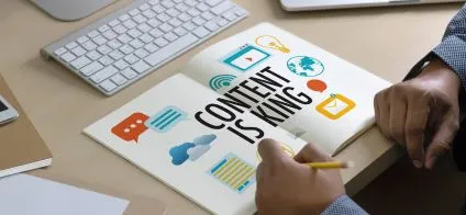 Clavier et livre avec 'Content is King', mains écrivant. Illustration de l'importance du contenu de qualité en ligne.