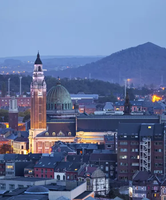 Vue aérienne de Charleroi au crépuscule, un panorama urbain captivant souvent mis en avant par une agence seo charleroi, montrant le beffroi Art déco illuminé.