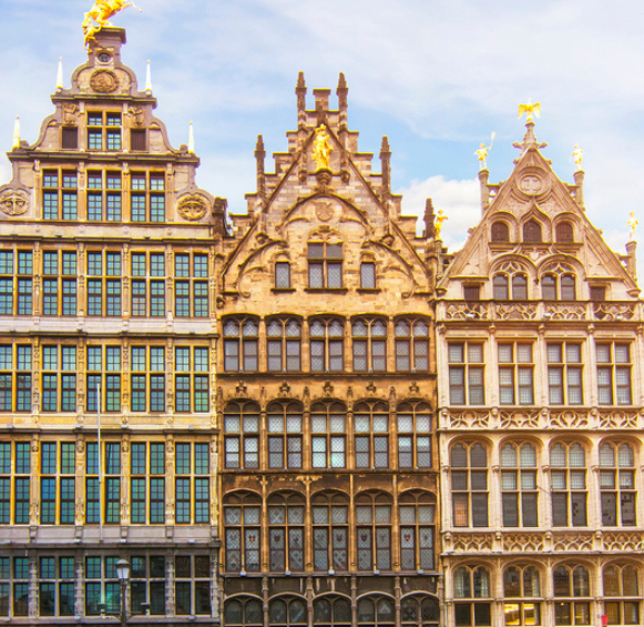 Gros plan sur les maisons des corporations richement ornées de la Grand-Place d'Anvers, avec leurs statues dorées et leurs détails architecturaux complexes.