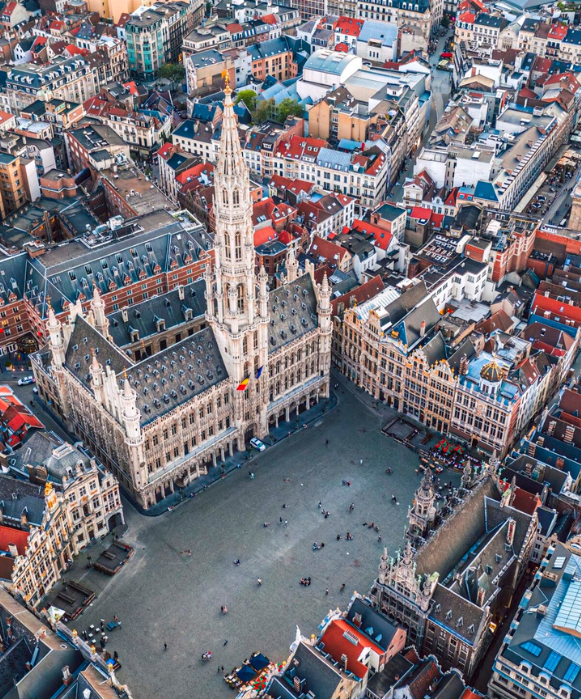 Vue aérienne en hauteur de la Grand-Place historique de Bruxelles, avec l'Hôtel de Ville et les maisons des corporations entourant la place pavée.