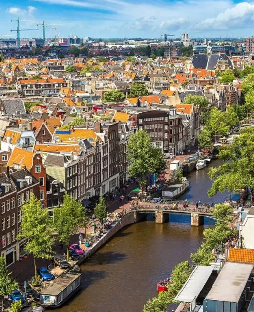 Vue panoramique plongeante sur les canaux et les toits d'Amsterdam.