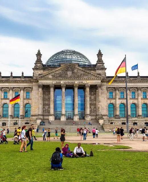 Façade historique du bâtiment du Reichstag à Berlin avec des drapeaux.